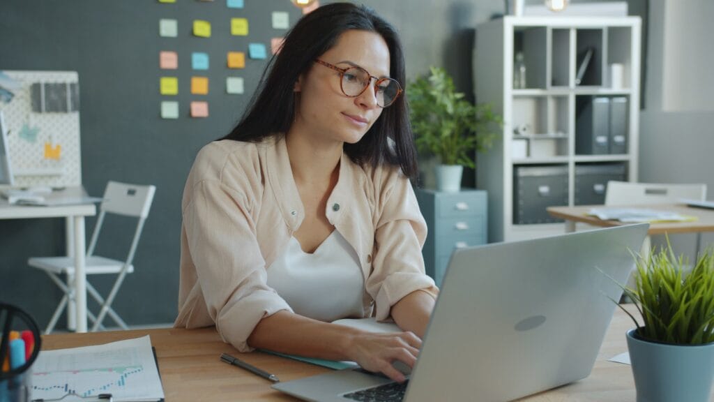 Healthcare professional reviewing caregiver scheduling on a laptop