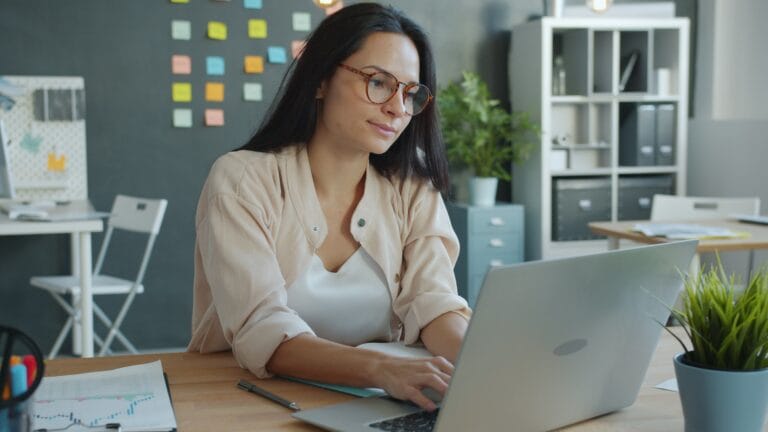 Healthcare professional reviewing caregiver scheduling on a laptop